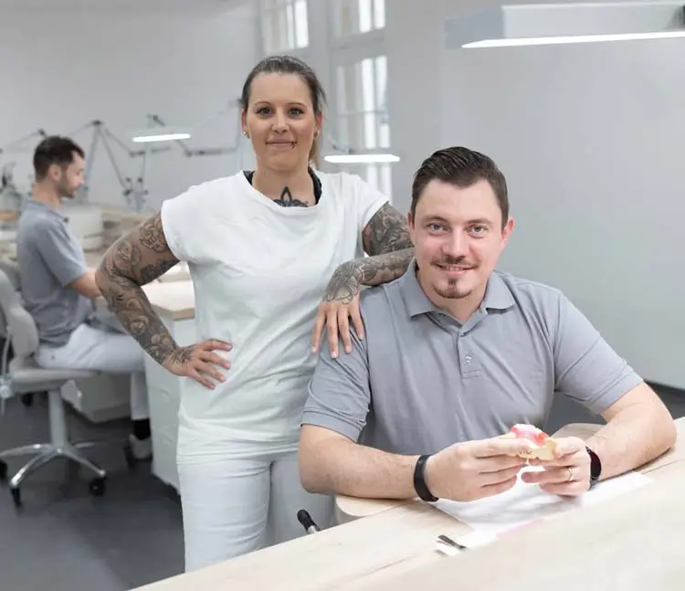 Zahn&auml;rztin und Zahntechniker besprechen ein Modell an einem Arbeitsplatz im Labor