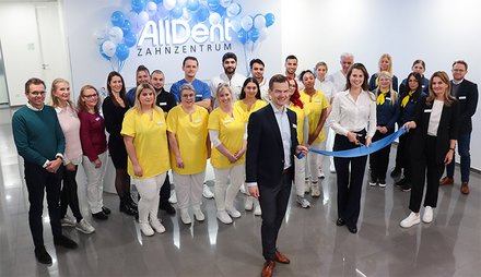 Geschäftsleitung mit Eröffnungsband und dem Team im Zahnzentrum Karlsruhe