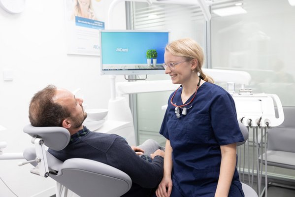 Oralchirurgin informiert Patient über den Behandlungsablauf
